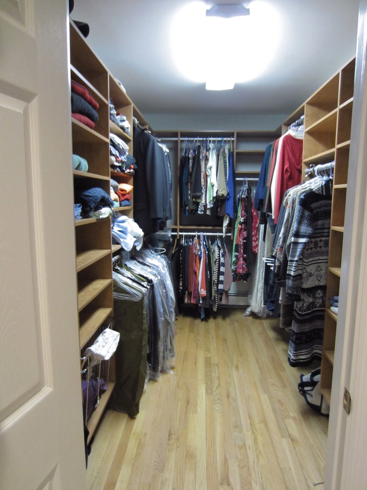 Inspiration for a large traditional gender neutral walk-in wardrobe in New York with open cabinets, medium wood cabinets and light hardwood flooring.