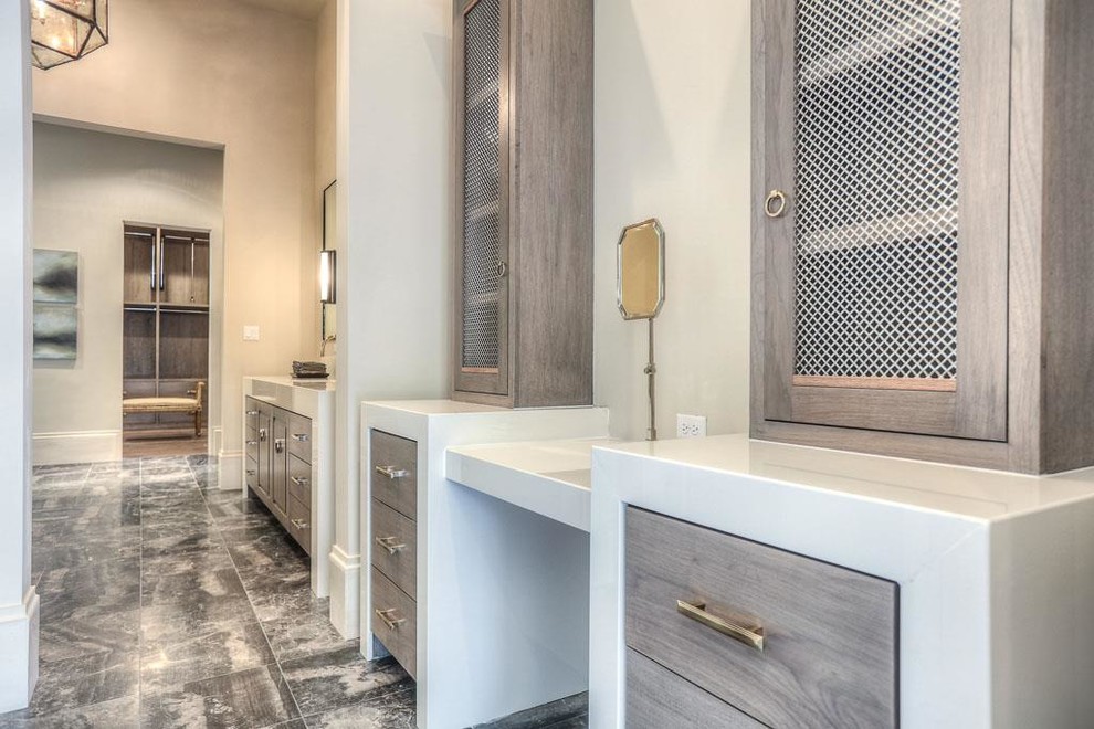 Inspiration for a large traditional gender neutral dressing room in Houston with flat-panel cabinets, light wood cabinets and marble flooring.
