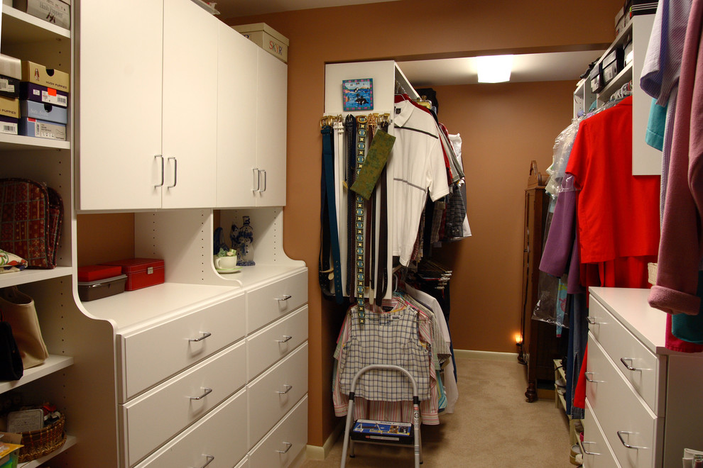 Ejemplo de armario vestidor unisex clásico de tamaño medio con armarios con paneles lisos, puertas de armario blancas y moqueta