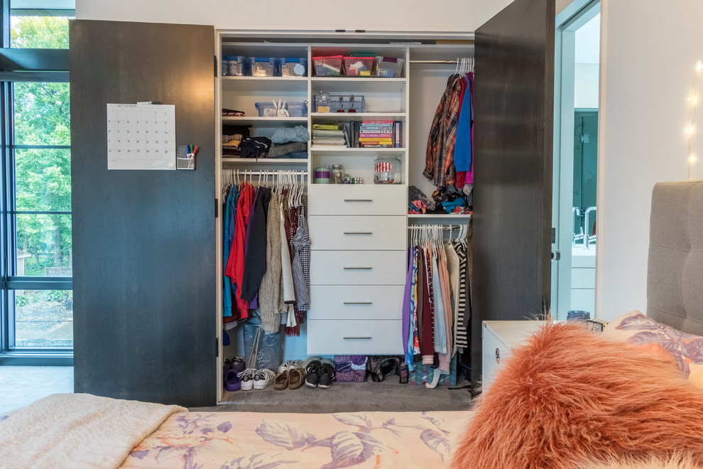 Example of a small minimalist women's carpeted reach-in closet design in Minneapolis with flat-panel cabinets and white cabinets