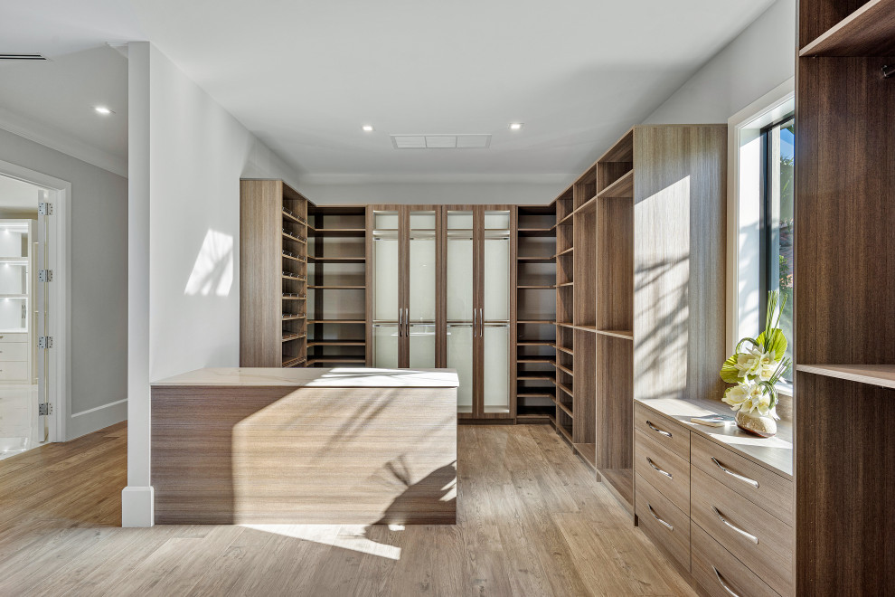 Neutrales Modernes Ankleidezimmer mit Einbauschrank, offenen Schränken, hellbraunen Holzschränken, braunem Holzboden und braunem Boden in Miami