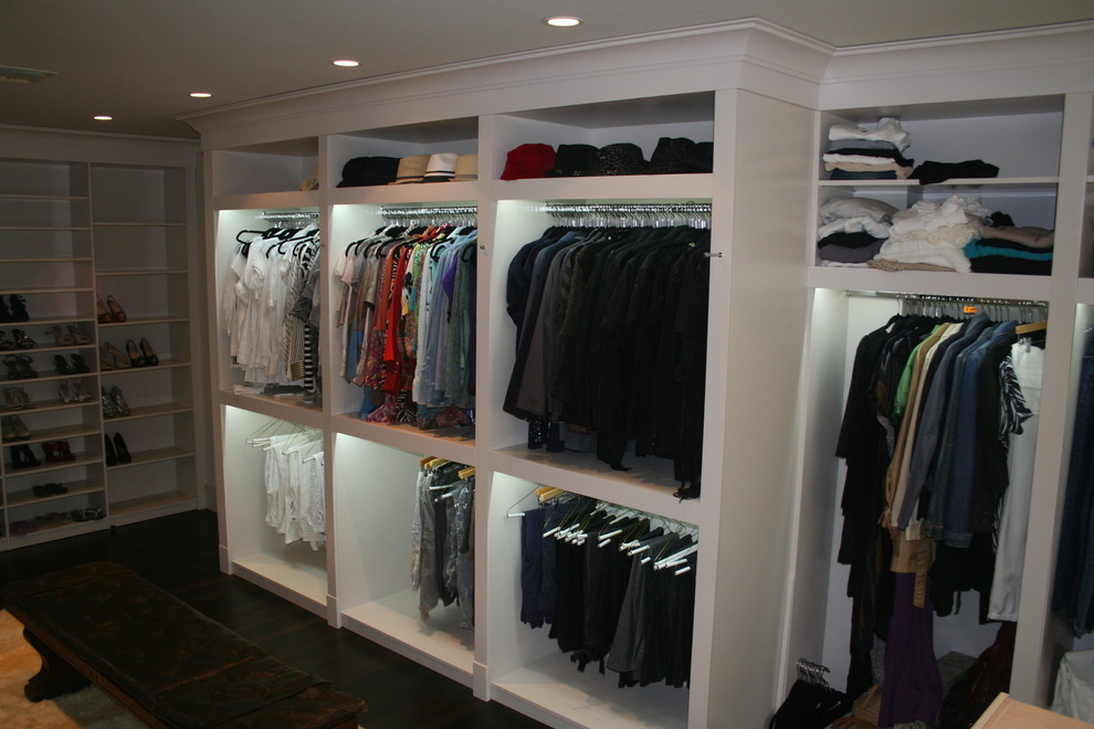 Bild på ett stort funkis walk-in-closet för könsneutrala, med öppna hyllor, vita skåp och mörkt trägolv