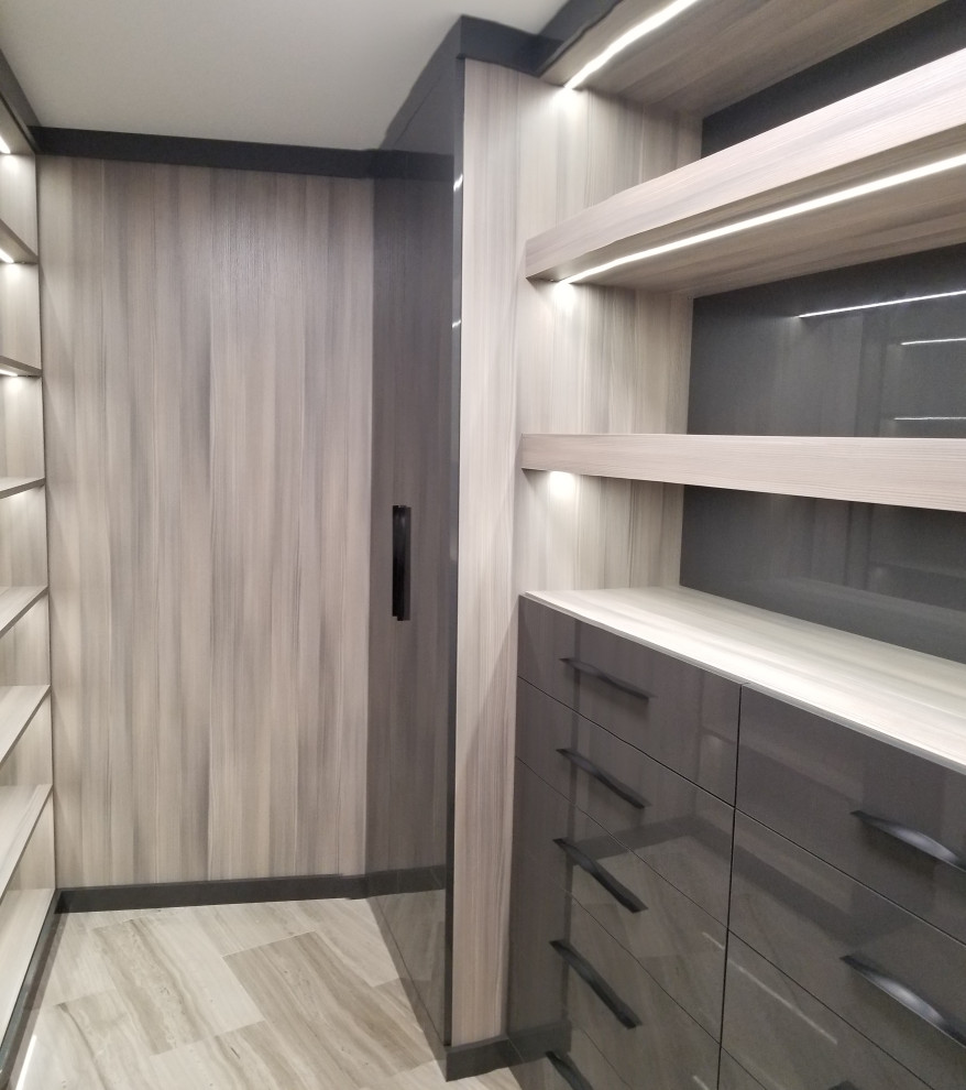 Diseño de armario vestidor unisex minimalista grande con armarios con paneles lisos, puertas de armario grises, suelo de baldosas de porcelana y suelo beige