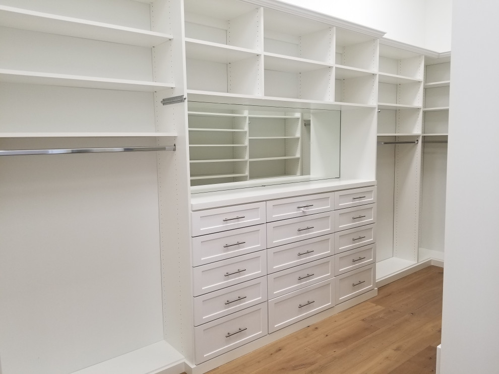 Inspiration for a large traditional gender neutral walk-in wardrobe in Miami with shaker cabinets, white cabinets, light hardwood flooring and beige floors.