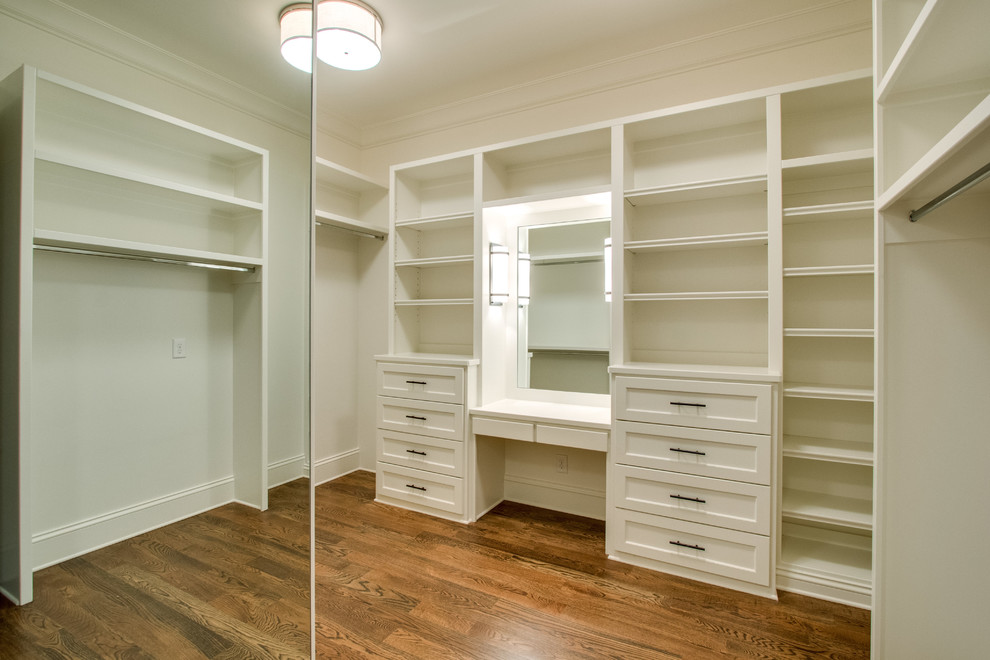 This is an example of a medium sized classic gender neutral walk-in wardrobe in Nashville with open cabinets, white cabinets and medium hardwood flooring.