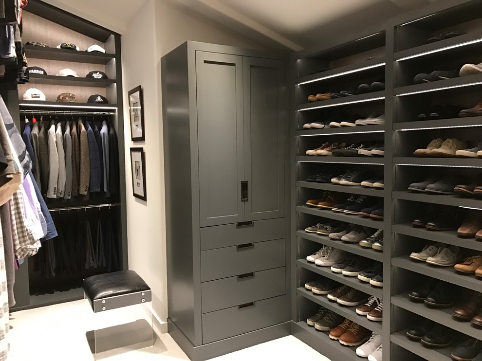 Ejemplo de vestidor de hombre actual grande con armarios con paneles lisos, puertas de armario grises, moqueta y suelo beige