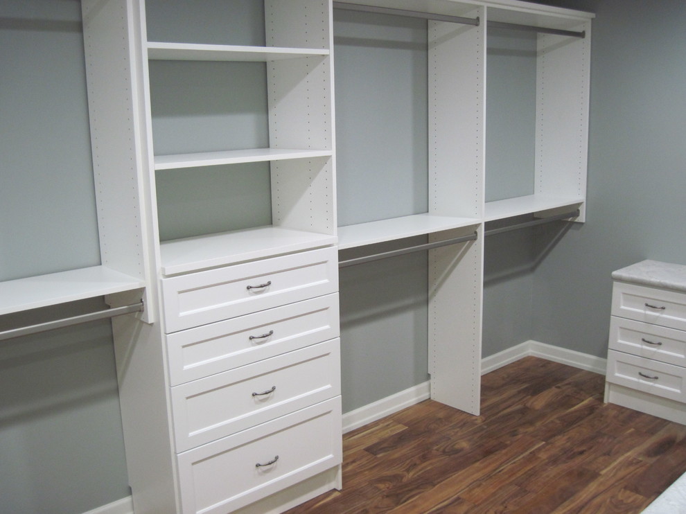 Foto de armario vestidor unisex tradicional de tamaño medio con armarios abiertos, puertas de armario blancas y suelo de madera oscura