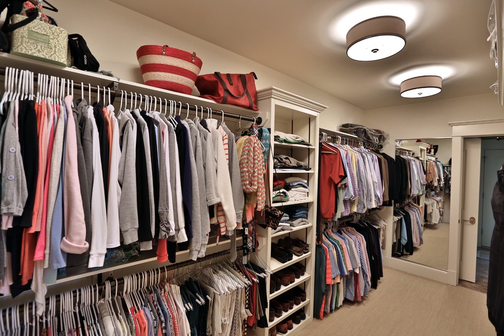 This is an example of a large classic gender neutral walk-in wardrobe in Chicago with open cabinets, white cabinets and carpet.