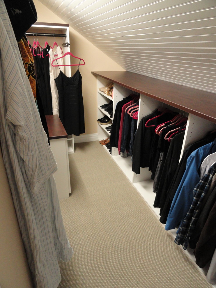This is an example of a medium sized contemporary walk-in wardrobe for men in New York with white cabinets, carpet, beige floors and open cabinets.