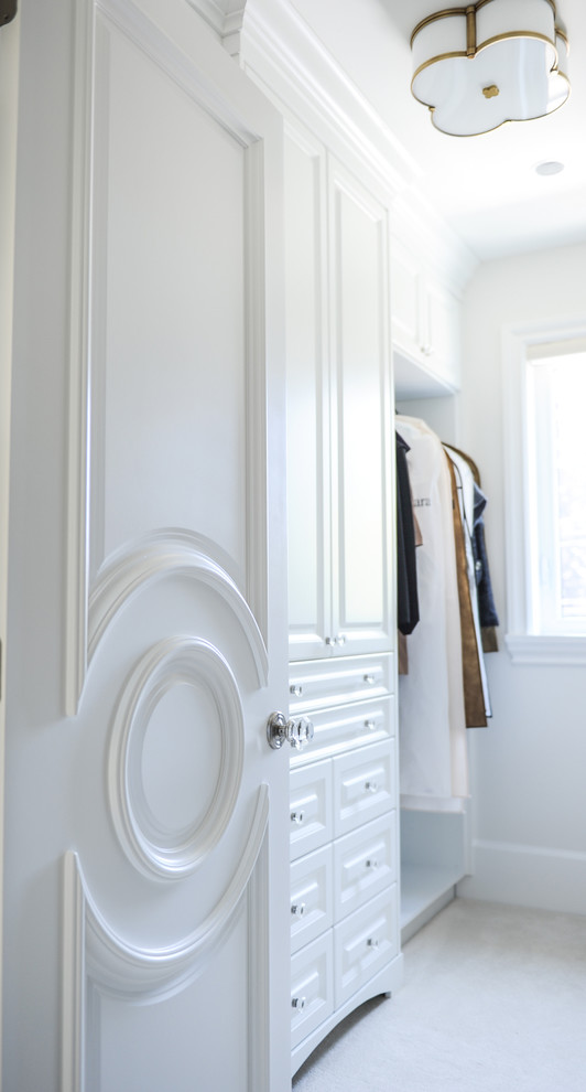 Medium sized traditional gender neutral walk-in wardrobe in Vancouver with raised-panel cabinets, white cabinets and carpet.