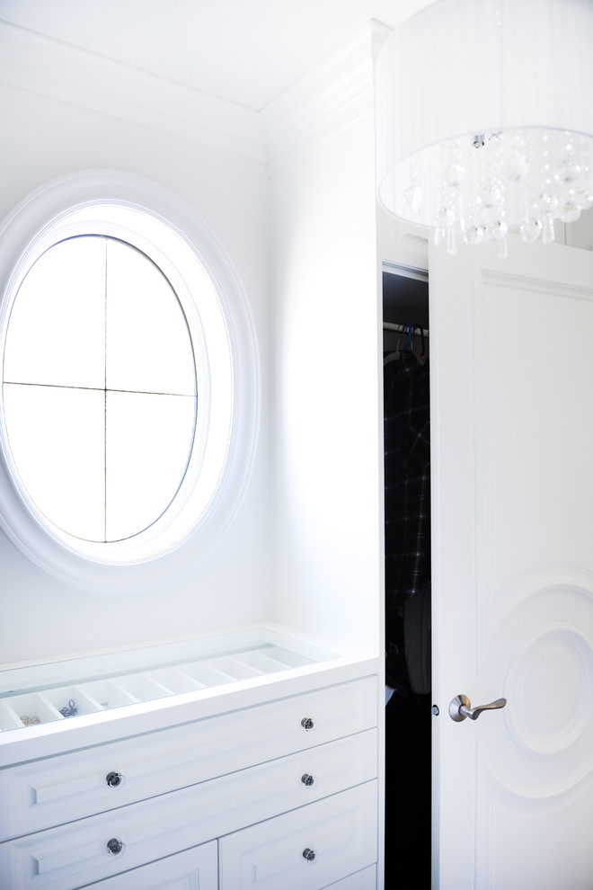 Diseño de armario vestidor unisex clásico renovado de tamaño medio con armarios con paneles con relieve, puertas de armario blancas y moqueta