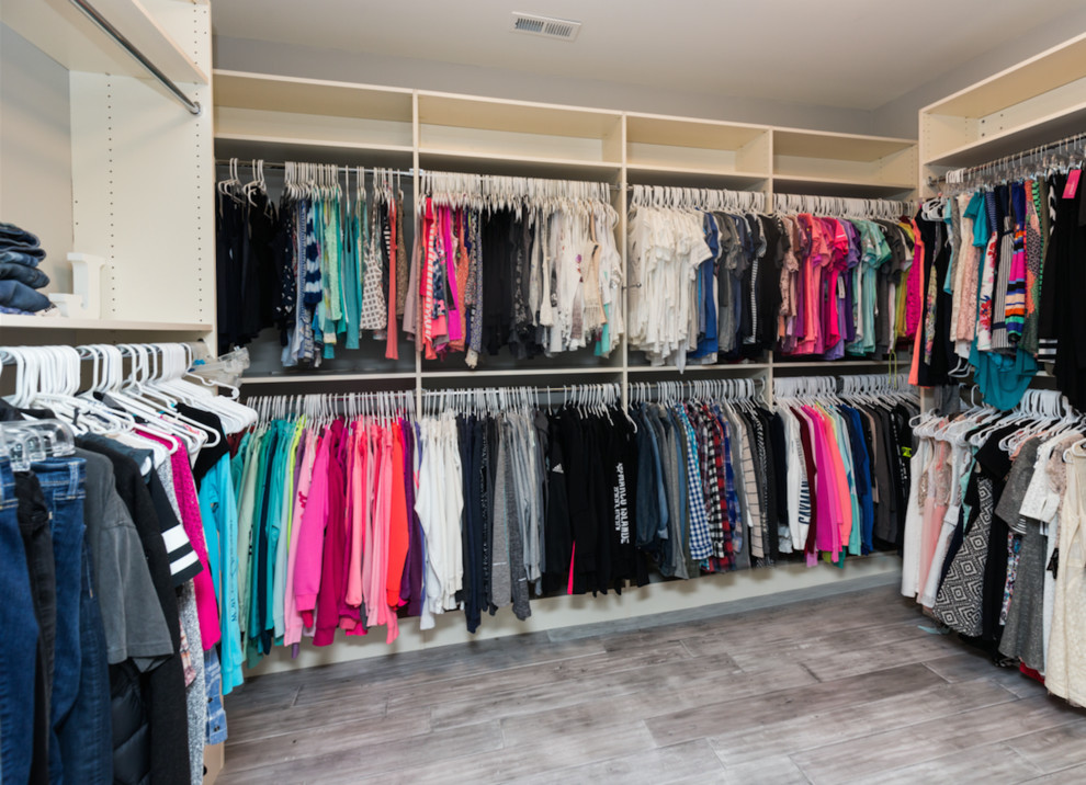 Foto de armario vestidor unisex clásico grande con armarios con paneles empotrados, puertas de armario blancas y suelo de madera en tonos medios