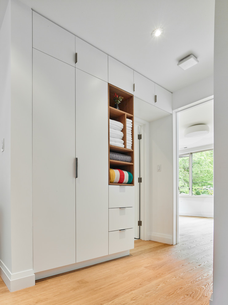 Источник вдохновения для домашнего уюта: шкаф в нише среднего размера, унисекс в современном стиле с белыми фасадами, плоскими фасадами, бежевым полом и светлым паркетным полом