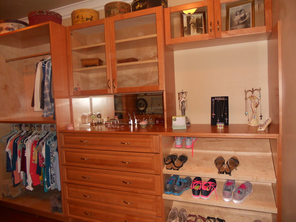 Example of a mid-sized classic gender-neutral dark wood floor and brown floor walk-in closet design in San Francisco with raised-panel cabinets and dark wood cabinets