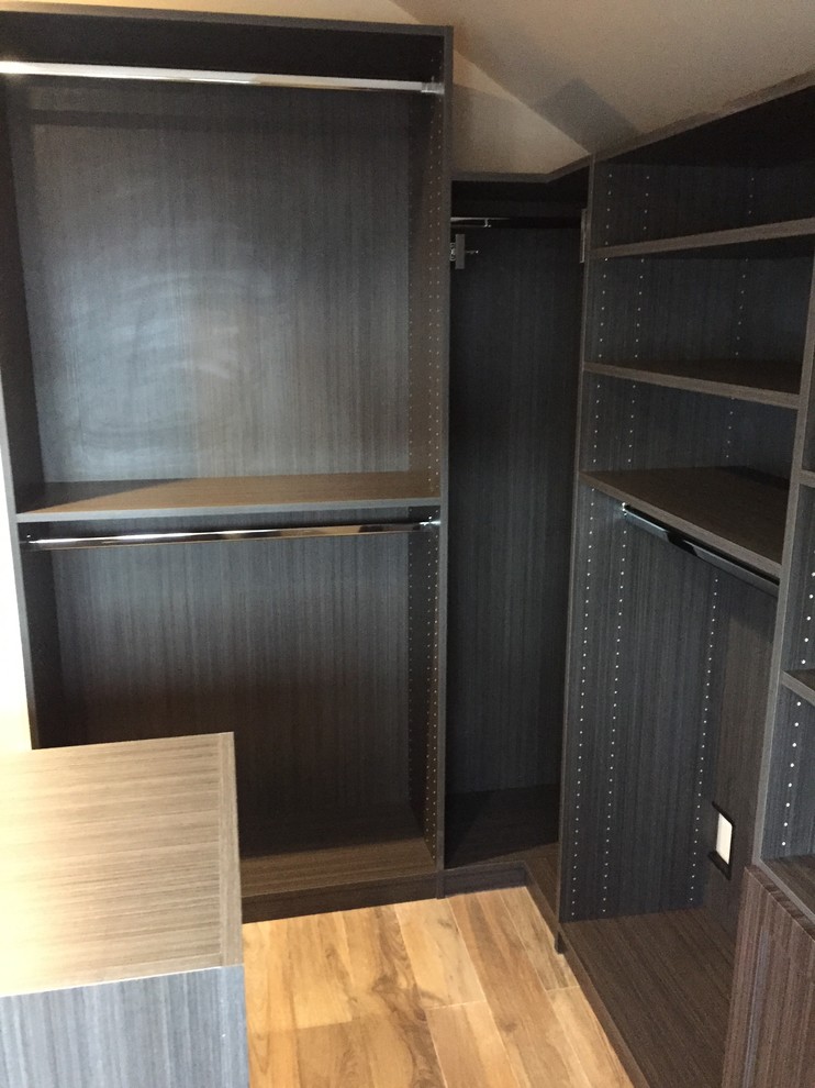 Foto de vestidor unisex de tamaño medio con armarios estilo shaker, puertas de armario de madera oscura y suelo marrón