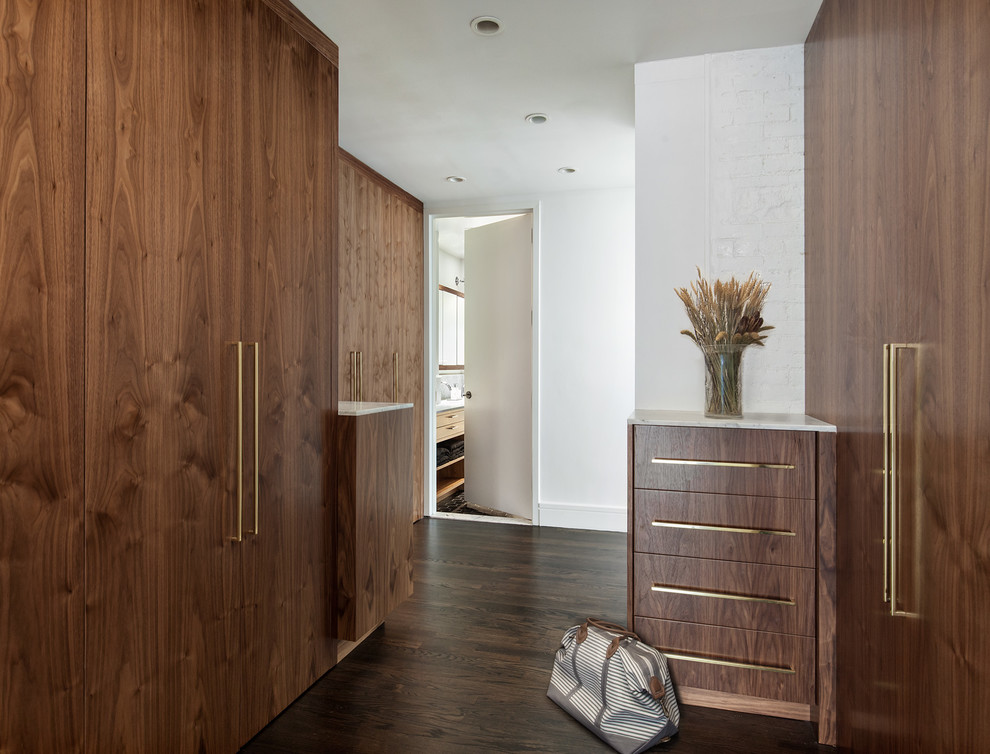 Großer, Neutraler Moderner Begehbarer Kleiderschrank mit flächenbündigen Schrankfronten, dunklen Holzschränken, braunem Holzboden und braunem Boden in New York