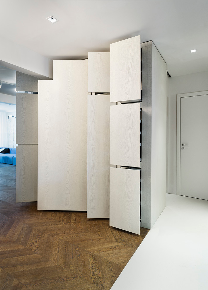 Foto di un armadio o armadio a muro unisex design con ante lisce, ante in legno chiaro e pavimento in legno massello medio