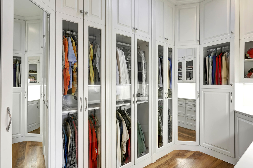 Ejemplo de armario vestidor unisex contemporáneo extra grande con suelo de madera clara