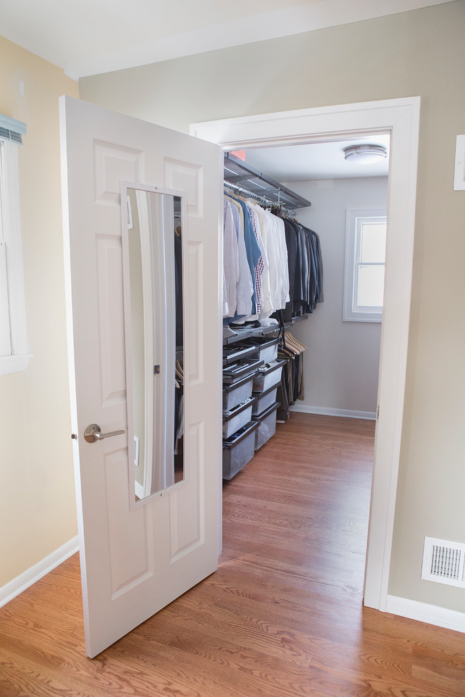 Photo of a large traditional gender neutral walk-in wardrobe in Chicago with medium hardwood flooring.