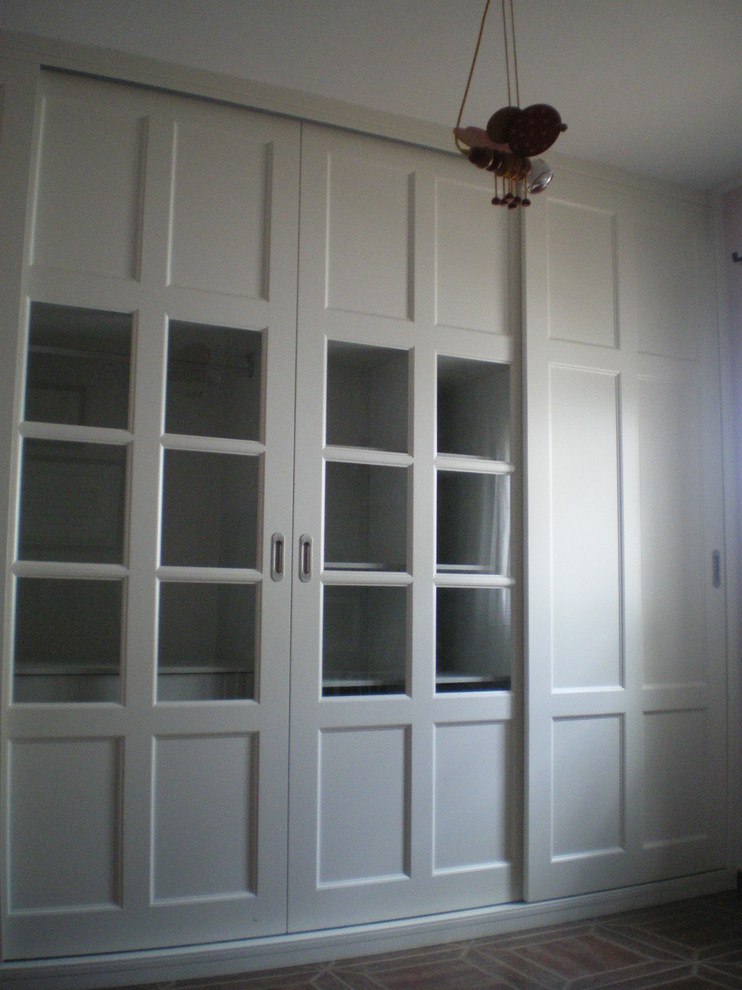 Medium sized classic gender neutral standard wardrobe in Other with glass-front cabinets and white cabinets.