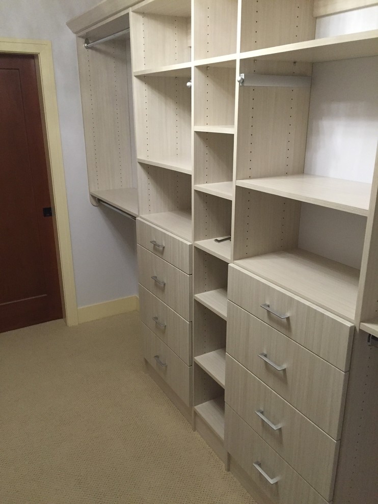 Photo of a medium sized modern gender neutral walk-in wardrobe in Other with open cabinets, light wood cabinets, carpet and beige floors.