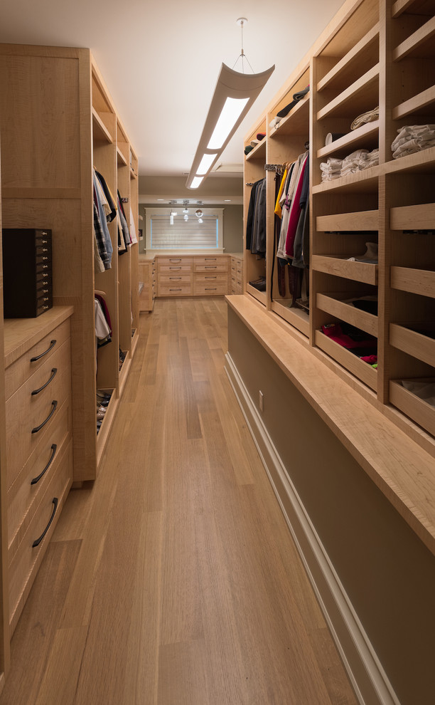 Modelo de armario vestidor unisex de estilo americano extra grande con armarios abiertos, puertas de armario de madera clara, suelo de madera clara y suelo beige
