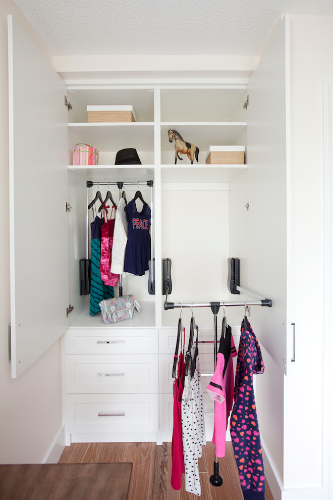 Modelo de armario clásico pequeño con armarios estilo shaker, puertas de armario blancas, suelo de madera clara y suelo beige