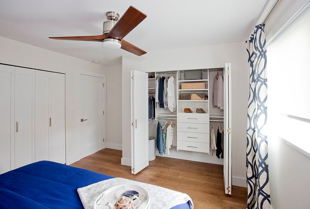 Imagen de armario tradicional renovado de tamaño medio con armarios con paneles lisos, puertas de armario blancas, suelo de madera en tonos medios y suelo beige