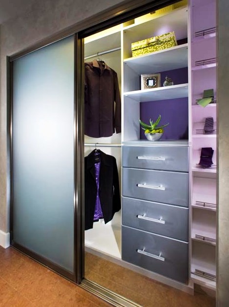 Inspiration för små moderna walk-in-closets för könsneutrala, med släta luckor och vita skåp