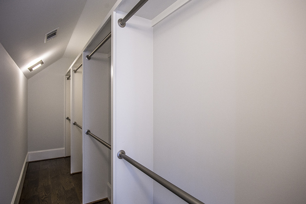 Foto de armario vestidor unisex actual pequeño con armarios abiertos, puertas de armario blancas y suelo de madera oscura