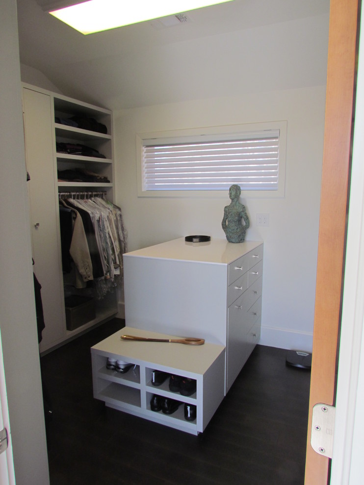 This is an example of a medium sized contemporary walk-in wardrobe for men in Atlanta with grey cabinets and dark hardwood flooring.