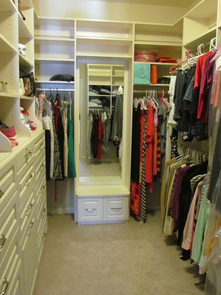 Ejemplo de armario vestidor unisex clásico de tamaño medio con armarios con paneles con relieve, puertas de armario blancas y moqueta