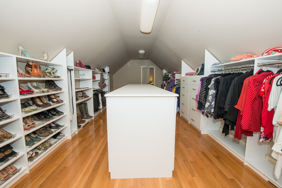 Ejemplo de armario vestidor unisex tradicional grande con armarios abiertos, puertas de armario blancas, suelo de madera clara y suelo marrón