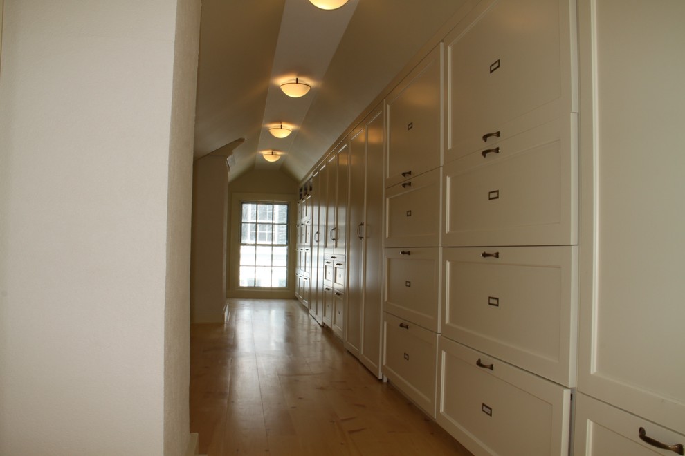 Bild på ett litet vintage walk-in-closet för könsneutrala, med vita skåp, mellanmörkt trägolv och luckor med infälld panel