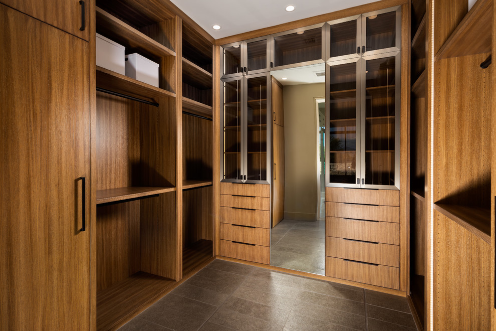 Cette image montre un dressing room design en bois brun de taille moyenne et neutre avec un placard à porte plane, un sol en carrelage de porcelaine et un sol gris.