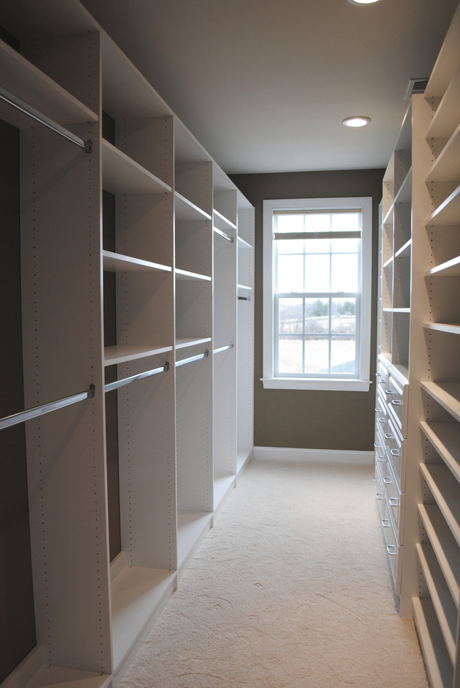 Medium sized traditional walk-in wardrobe in DC Metro with raised-panel cabinets, white cabinets and carpet.