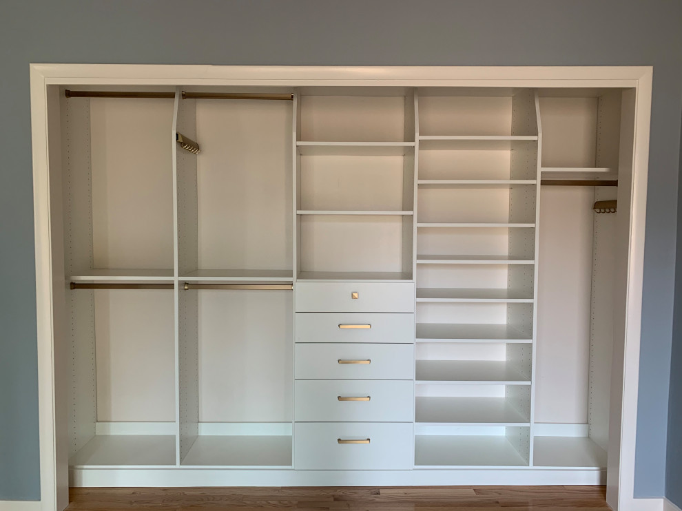 Small traditional gender neutral standard wardrobe in Other with flat-panel cabinets, white cabinets, light hardwood flooring and yellow floors.