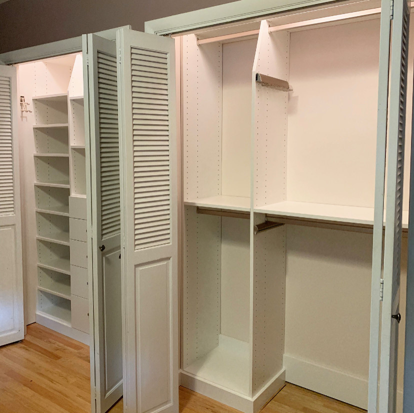 Inspiration for a small classic gender neutral standard wardrobe in Other with flat-panel cabinets, white cabinets, light hardwood flooring and yellow floors.