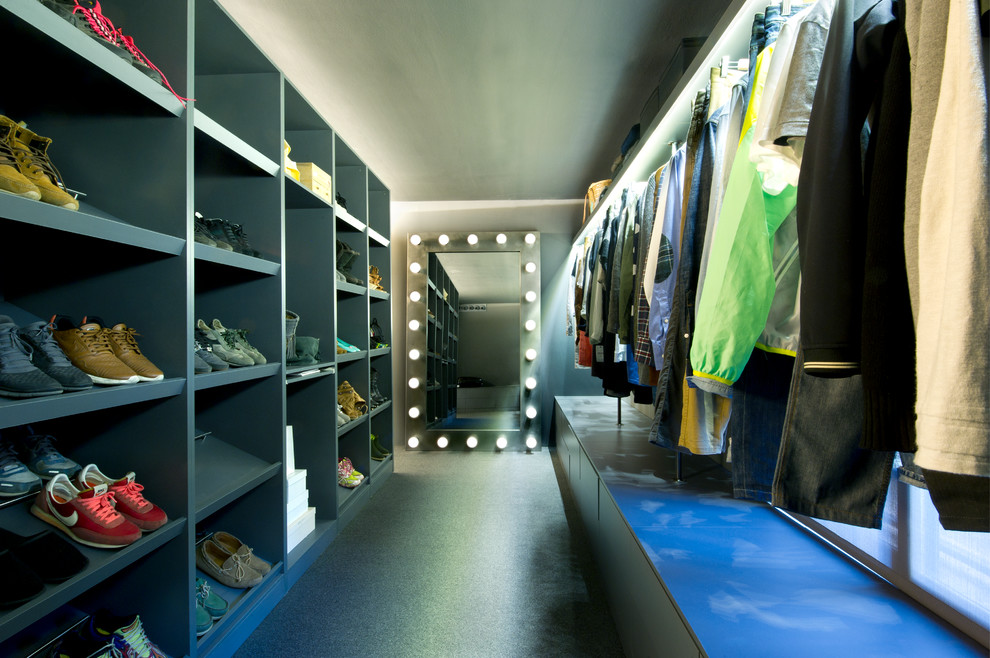 Industriell inredning av ett stort walk-in-closet för könsneutrala, med öppna hyllor, grå skåp och svart golv