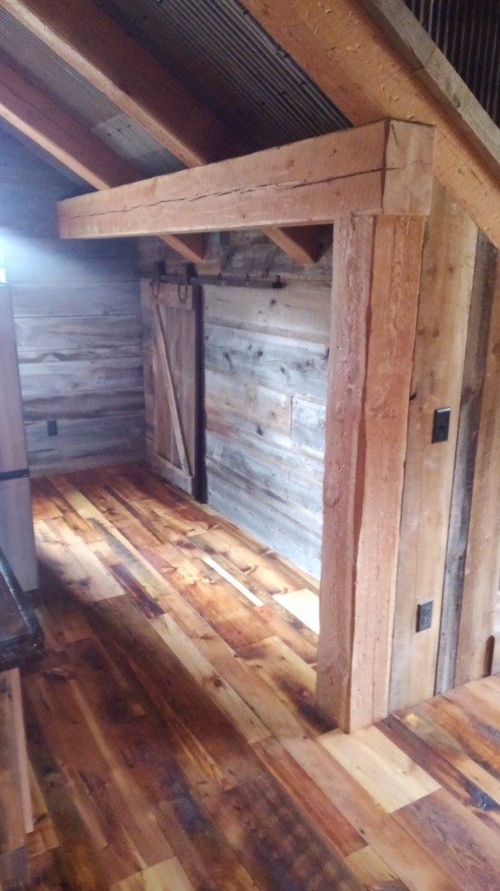 Rustik inredning av ett mellanstort walk-in-closet för könsneutrala, med mellanmörkt trägolv och brunt golv