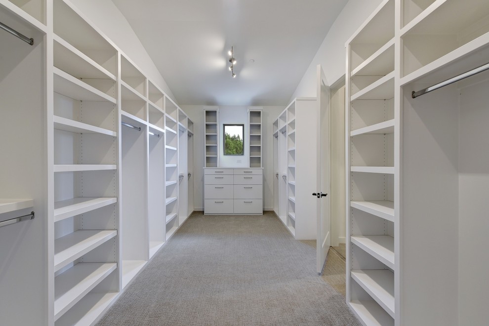 Photo of a large classic gender neutral walk-in wardrobe in Austin with white cabinets, carpet and grey floors.