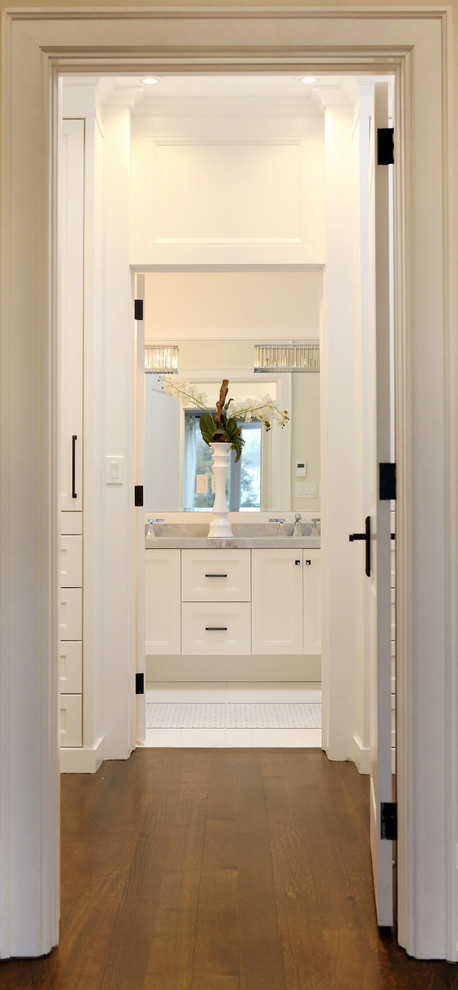 Inspiration for a mid-sized transitional gender-neutral dark wood floor walk-in closet remodel in Toronto with flat-panel cabinets and white cabinets