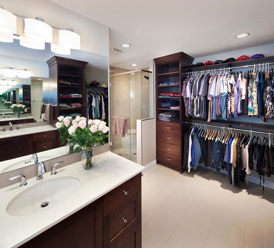 Medium sized classic gender neutral dressing room in Calgary with flat-panel cabinets, medium wood cabinets and ceramic flooring.