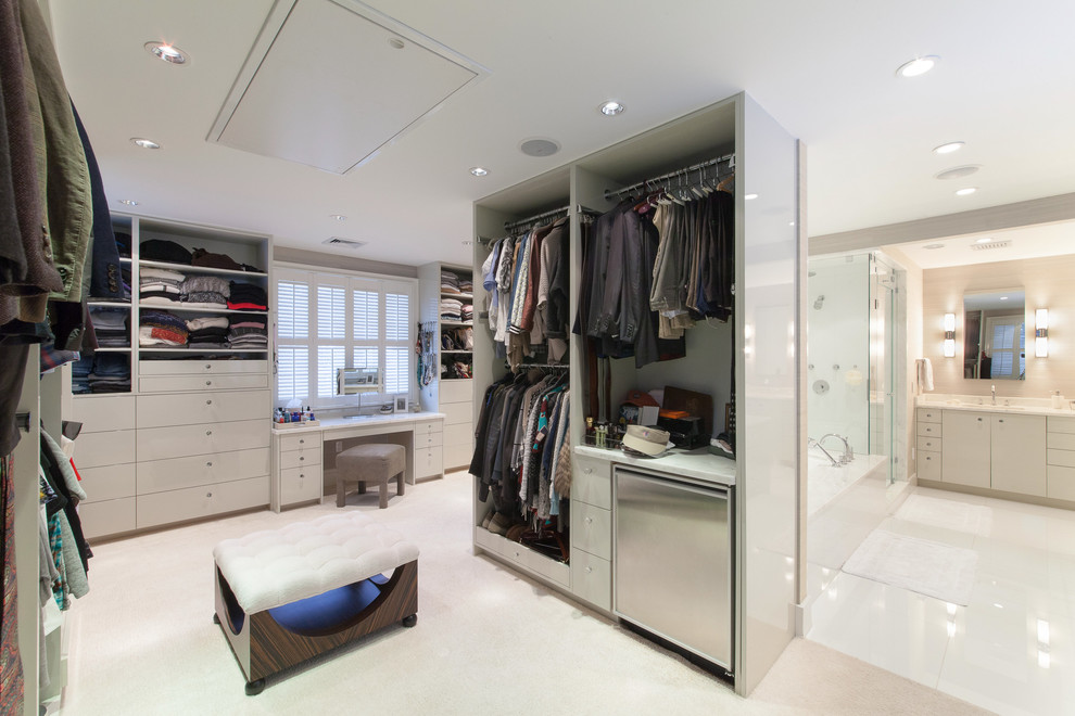 This is an example of a contemporary wardrobe for men in Boston with flat-panel cabinets, white cabinets, carpet and beige floors.