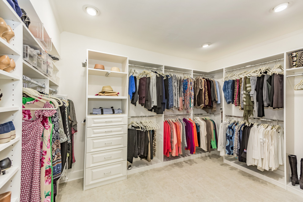 Large eclectic dressing room for women in Tampa with raised-panel cabinets, white cabinets, travertine flooring and beige floors.