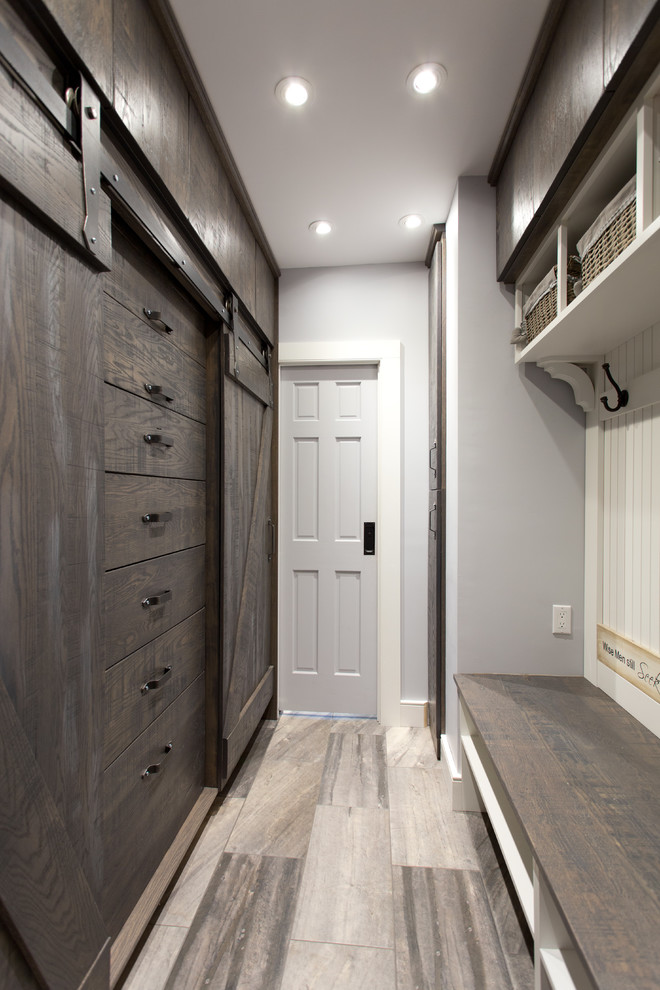 Imagen de armario vestidor unisex costero de tamaño medio con puertas de armario de madera en tonos medios, suelo de baldosas de porcelana y armarios con paneles lisos