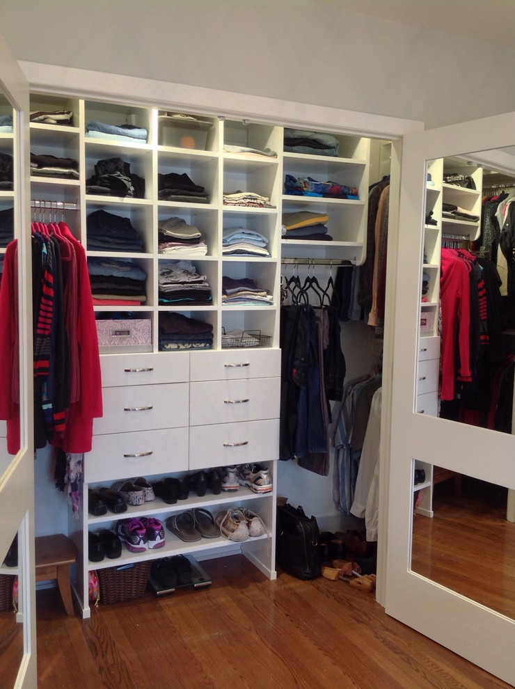 Modelo de armario unisex clásico renovado de tamaño medio con armarios con paneles lisos, puertas de armario blancas y suelo de madera en tonos medios