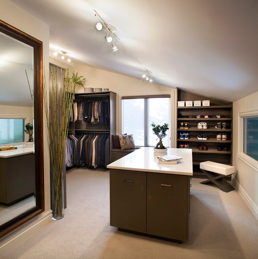 Walk-in closet - large zen men's carpeted walk-in closet idea in Calgary with flat-panel cabinets and dark wood cabinets