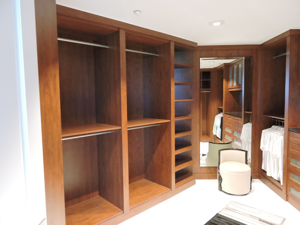 Photo of a large contemporary gender neutral walk-in wardrobe in Miami with shaker cabinets, medium wood cabinets and carpet.
