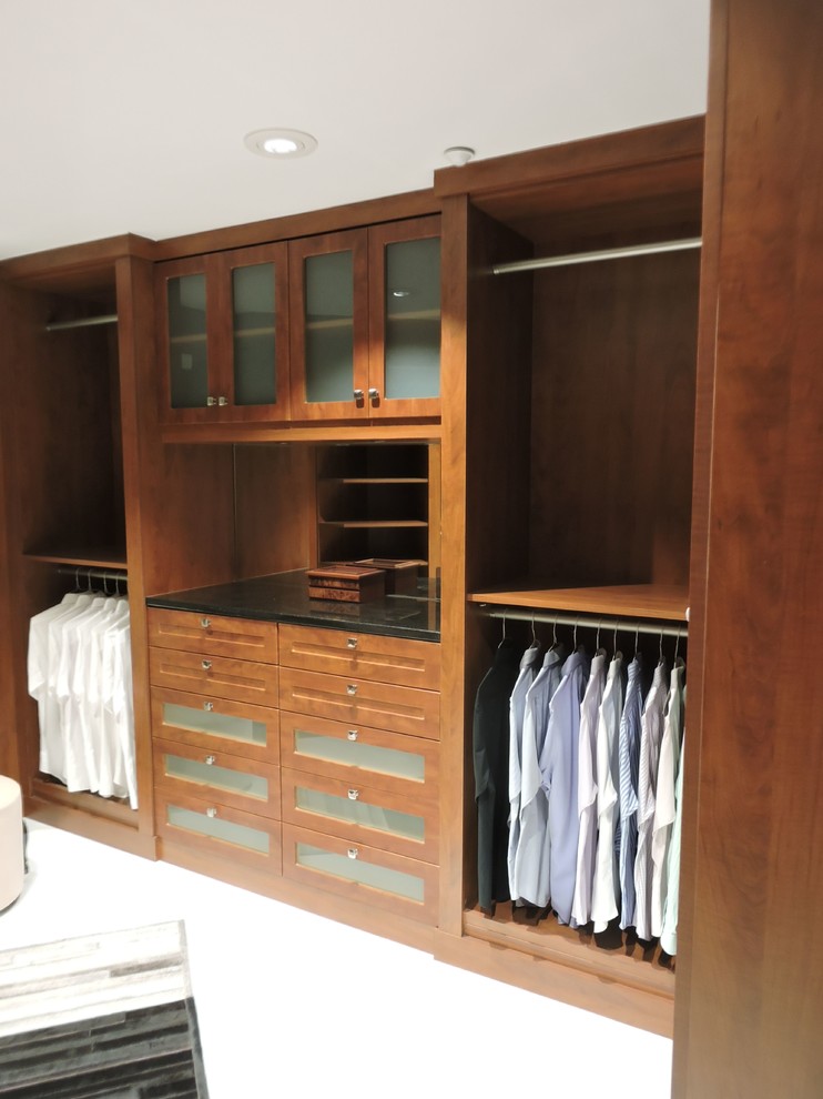 Example of a large trendy gender-neutral carpeted walk-in closet design in Miami with shaker cabinets and medium tone wood cabinets